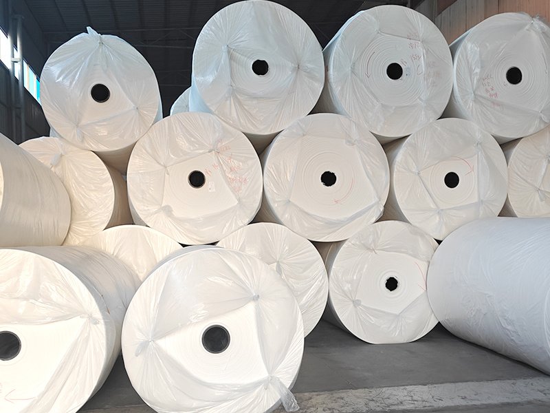 Virgin pulp mother jumbo rolls wrapped and stacked in the converting warehouse