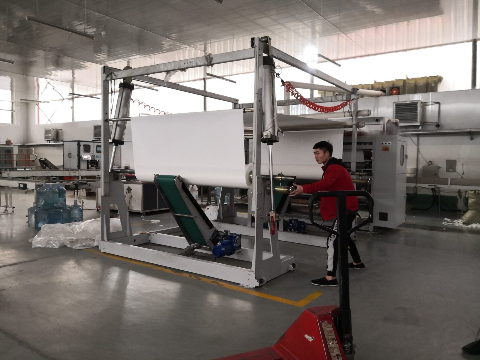 Operator loading a tissue web onto the rewind stand